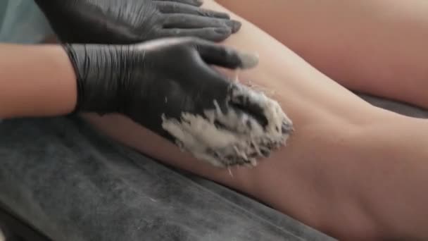 Kosmetička dělá shugaring na nohách mladé ženy. — Stock video