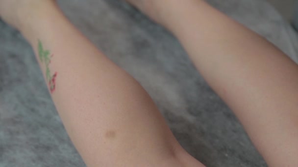 Esthéticienne traite les jambes d'une jeune femme après avoir secoué. — Video