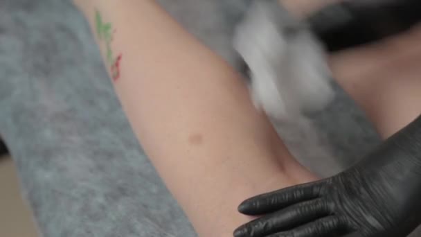 Güzellik uzmanı, titredikten sonra genç bir kadının bacaklarını tedavi eder.. — Stok video