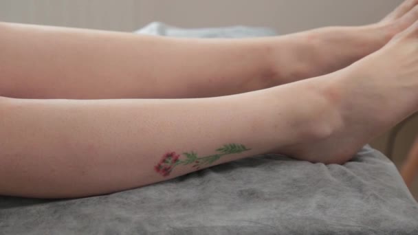 Beautist behandlar benen på en ung kvinna efter shugaring. — Stockvideo