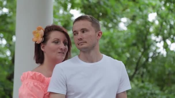 Young beautiful lovers in the park near the columns. — Stock Video