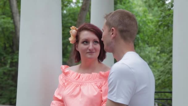 Jóvenes amantes hermosos en el parque cerca de las columnas . — Vídeo de stock