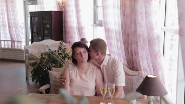 Schönes Liebespaar kuschelt in einem Restaurant. — Stockvideo