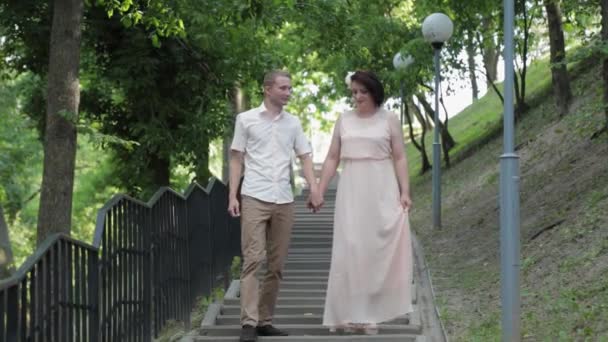 Young lovers on the stairs in the park. — Stock Video