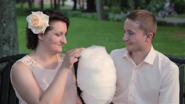 Young lovers eat cotton candy. — Stock Video