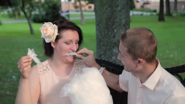 Young lovers eat cotton candy. — Stock Video