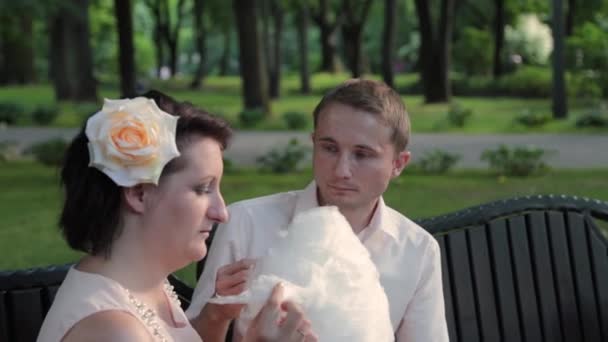 Young lovers eat cotton candy. — Stock Video