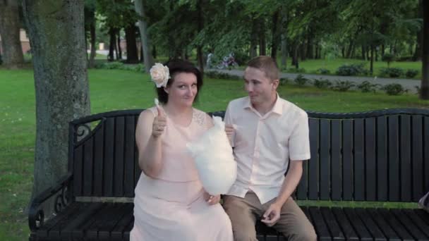 Young lovers eat cotton candy. — Stock Video