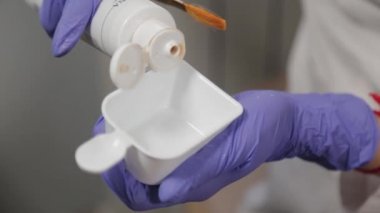 Profesyonel bir güzellik uzmanı yüz maskesini özel bir konteynırda karıştırır..