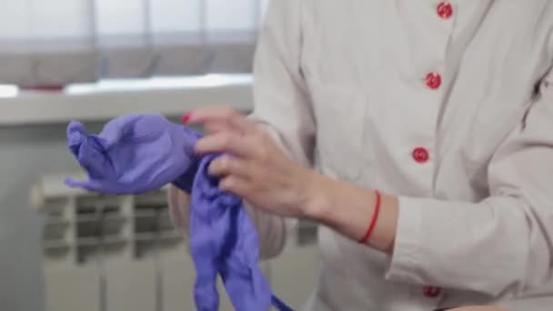 Professionele schoonheidsspecialiste trekt rubber handschoenen aan voor de procedure. — Stockvideo