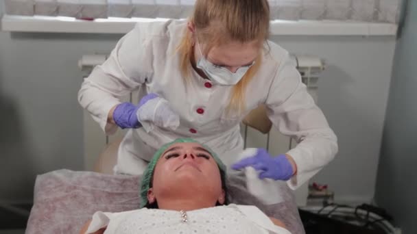 Профессиональный косметолог моет женщину перед процедурой . — стоковое видео