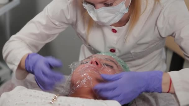 一个专业的美容师把一部影片贴在脸上. — 图库视频影像