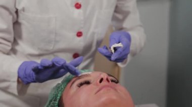 Profesyonel güzellik uzmanı yüzüne maske takar..