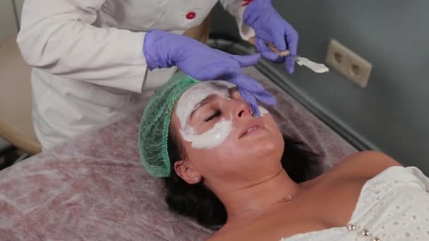 プロの美容師は顔にマスクを適用します。. — ストック動画