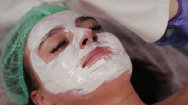 Professionelle Kosmetikerin trägt Maske auf das Gesicht auf. — Stockvideo