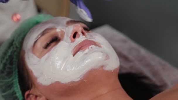 Professionelle Kosmetikerin trägt Maske auf das Gesicht auf. — Stockvideo