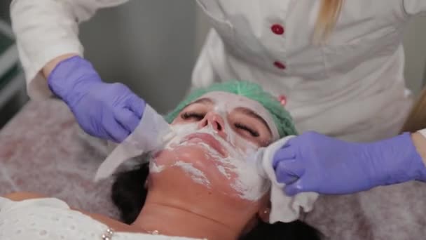 Професійний косметолог миє жінку перед процедурою . — стокове відео