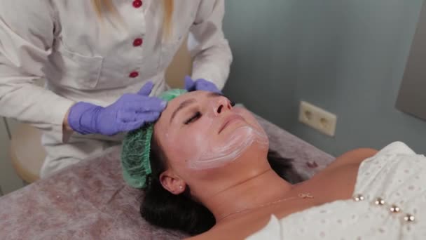Професійний косметолог миє жінку і масажує її обличчя . — стокове відео