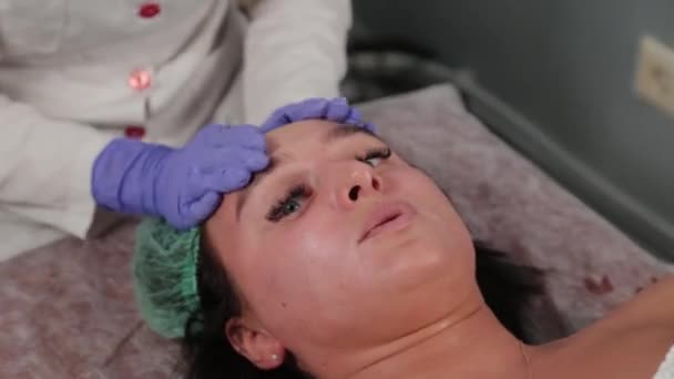 Esthéticienne professionnelle lave une femme et masse son visage. — Video