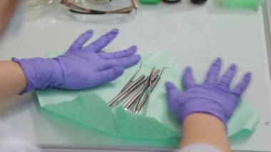 Kadın dişçi tedavi için aletleri çıkarıyor..