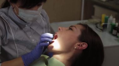 Kadın dişçi bir tıp merkezinde dişleri tedavi eder..