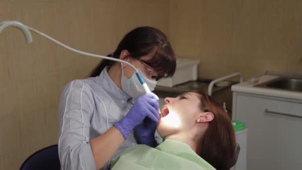 Kvinna tandläkare behandlar tänder i en vårdcentral. — Stockvideo