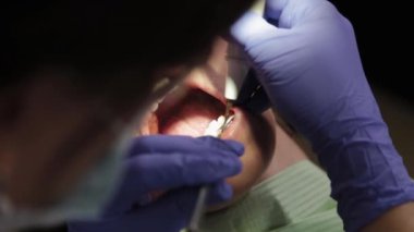 Kadın dişçi bir tıp merkezinde dişleri tedavi eder..