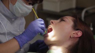 Kadın dişçi bir tıp merkezinde dişleri tedavi eder..