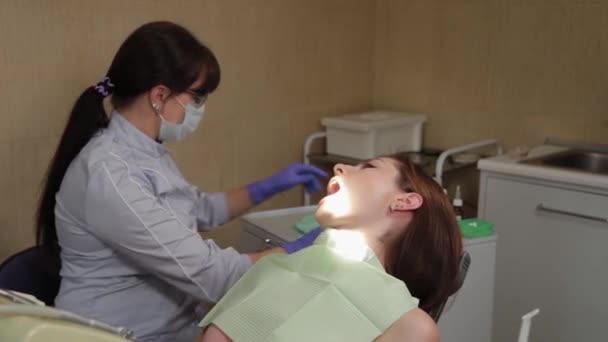 Mulher dentista trata dentes em um centro médico . — Vídeo de Stock