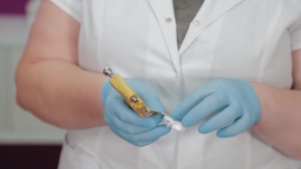 Ärztin bereitet Instrument für Ohrpiercing vor. — Stockvideo