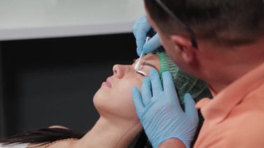 Kalıcı makyaj sanatçısı kirpiklere anestezi uygular..