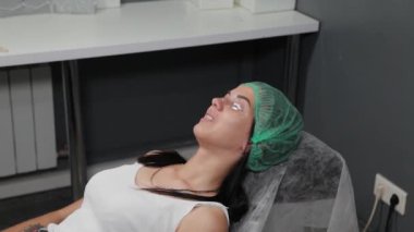 Kirpiklerinde ağrı kesici jeli olan bir kadın..