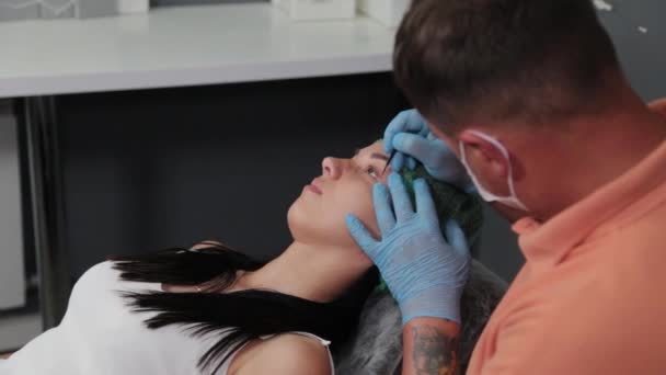 A pretty woman is marked out with permanent makeup areas. — Stock Video