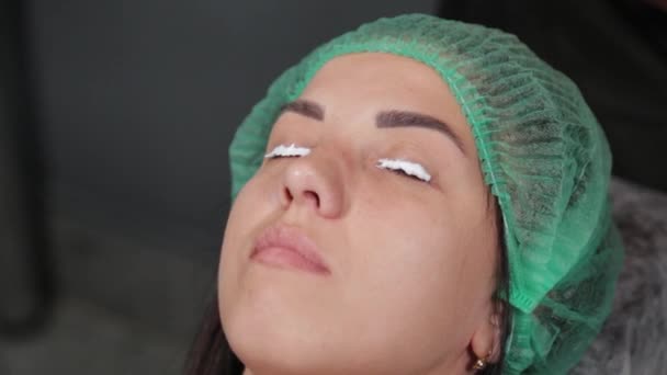The permanent makeup artist applies an anesthetic to the lashes. — Stock Video