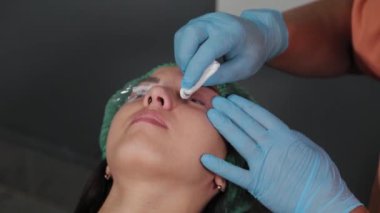 Kalıcı makyaj ustası, acı giderici jeli kirpiklerinden ayırır..