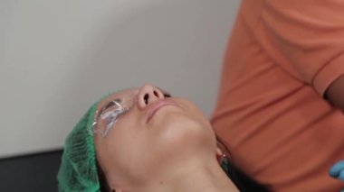 Kalıcı bir makyöz, bir kadının göz kapaklarına dövme yaptırır..