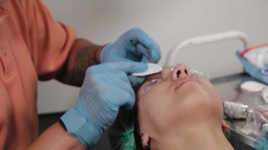 Kalıcı bir makyöz, bir kadının göz kapaklarına dövme yaptırır..