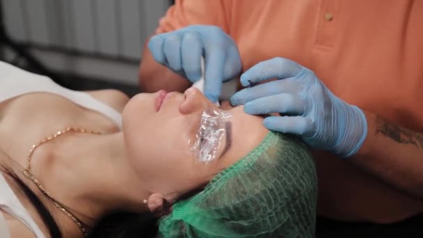 A permanent makeup artist gets a tattoo on a womans upper eyelids.