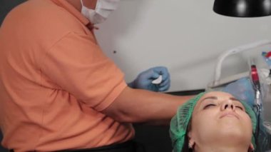 Kalıcı bir makyöz, bir kadının göz kapaklarına dövme yaptırır..