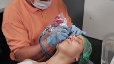 Kalıcı bir makyöz, bir kadının göz kapaklarına dövme yaptırır..