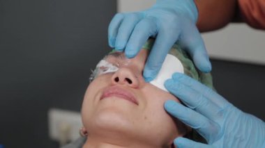 Kirpiklerinde ağrı kesici jeli olan bir kadın..