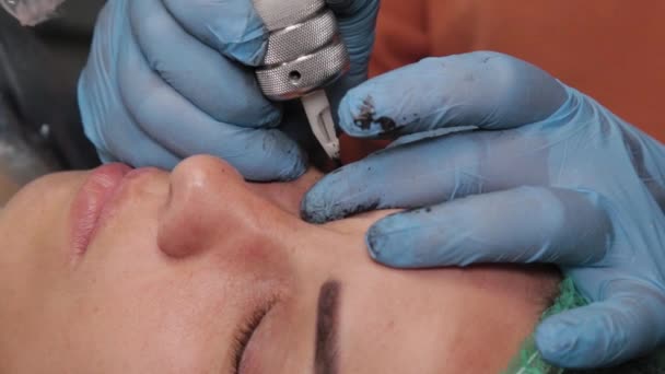 Un artist de machiaj permanent primește un tatuaj pe pleoapele superioare ale unei femei . — Videoclip de stoc