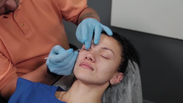 A pretty woman is marked out with permanent makeup areas. — Stock Video