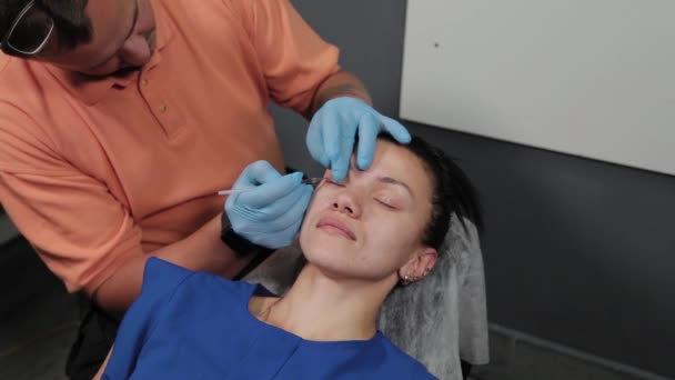 A pretty woman is marked out with permanent makeup areas. — Stock Video