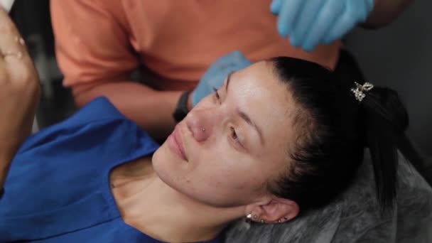 Una mujer bonita está marcada con áreas de maquillaje permanente. — Vídeo de stock