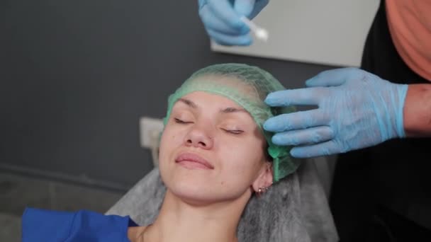 The permanent makeup artist applies an anesthetic to the lashes. — Stock Video