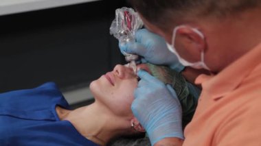 Kalıcı bir makyöz, bir kadının göz kapaklarına dövme yaptırır..