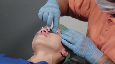 Kalıcı bir makyöz, bir kadının göz kapaklarına dövme yaptırır..