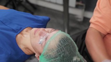 Kalıcı bir makyöz, bir kadının göz kapaklarına dövme yaptırır..