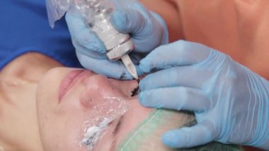 Kalıcı bir makyöz, bir kadının göz kapaklarına dövme yaptırır..